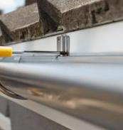 contractor installing new gutter system on residential home